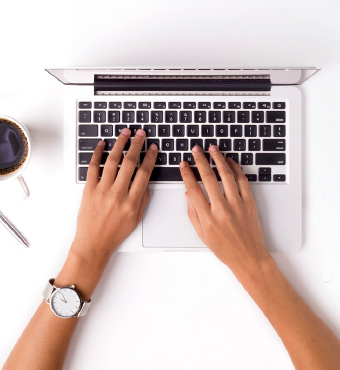 Two hands typing on a laptop
